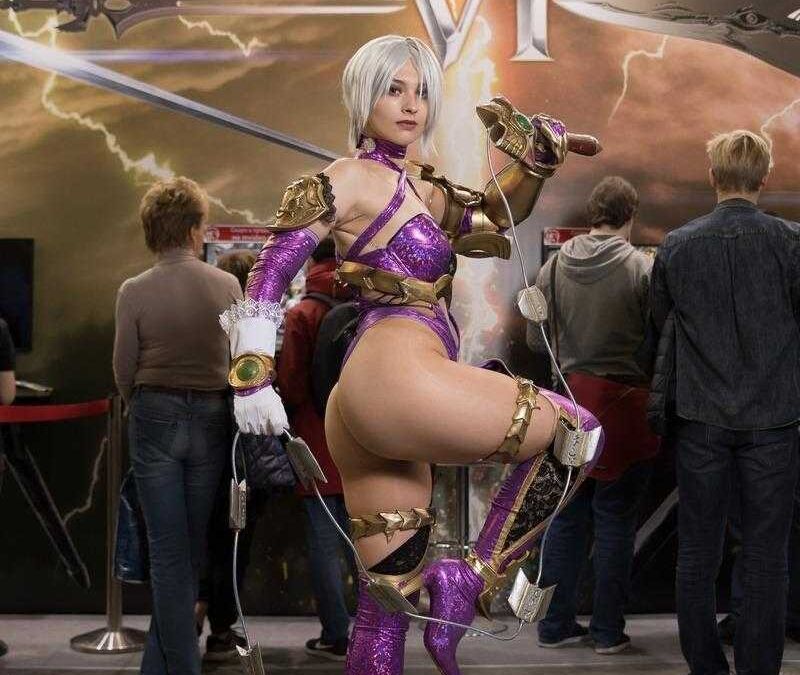 Косплей девушки в ярком костюме с оружием на выставке игроМир 2018 и Comic Con