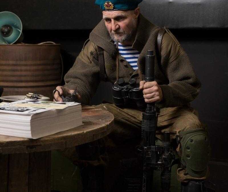 Мужчина в военной форме с биноклем и шлемом