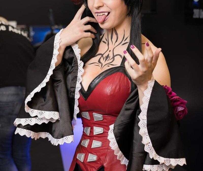 Женщина в костюме героини видеоигры с рогами и татуировкой на груди