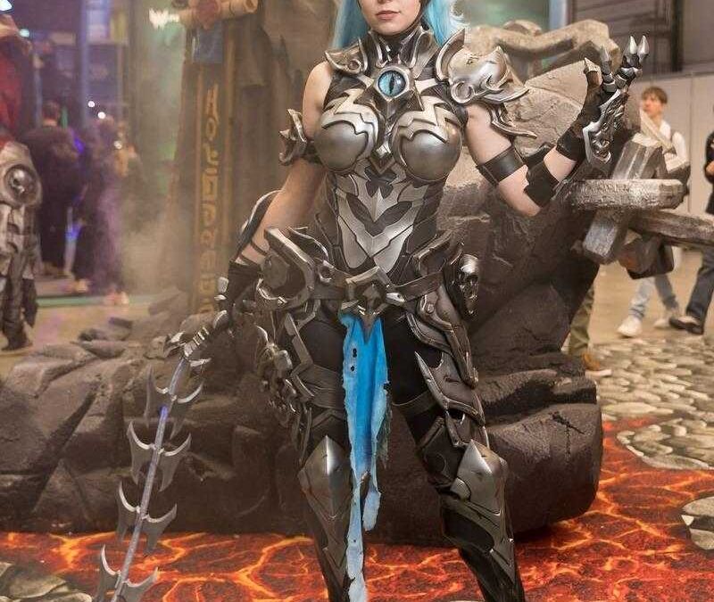 Косплей героини с голубыми волосами и броней на ИгроМир 2018