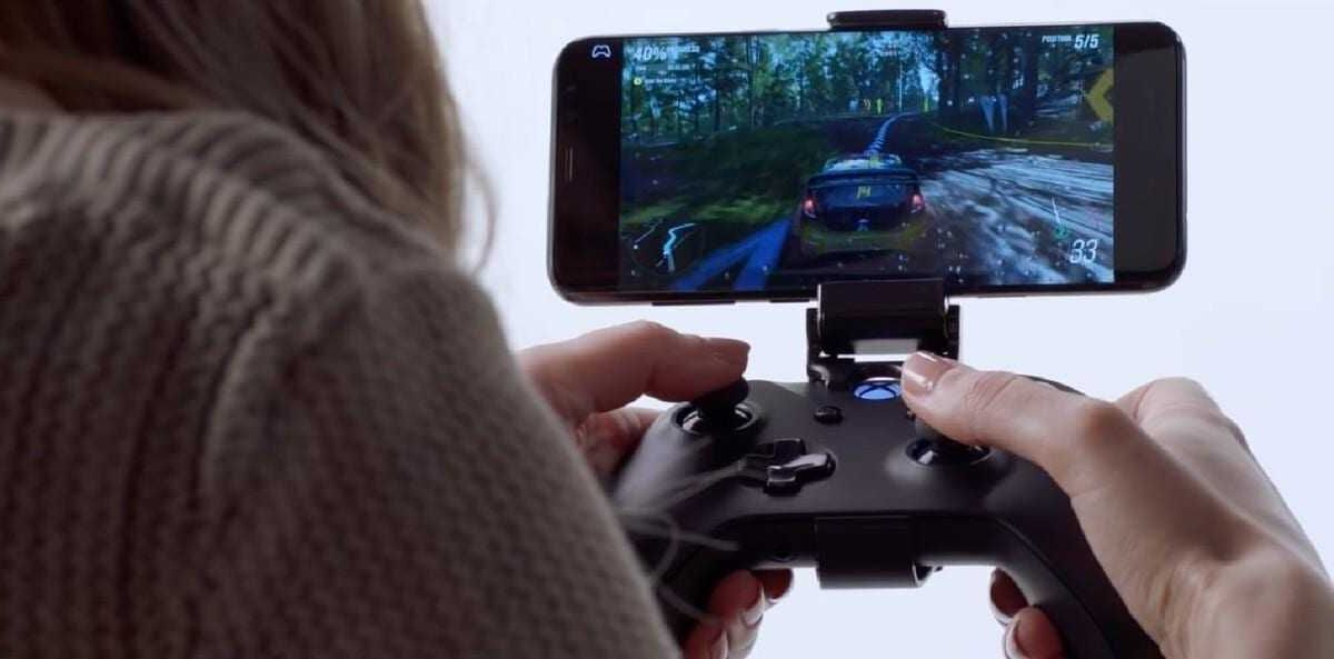 Игрок держит контроллер Xbox для смартфона с помощью держателя