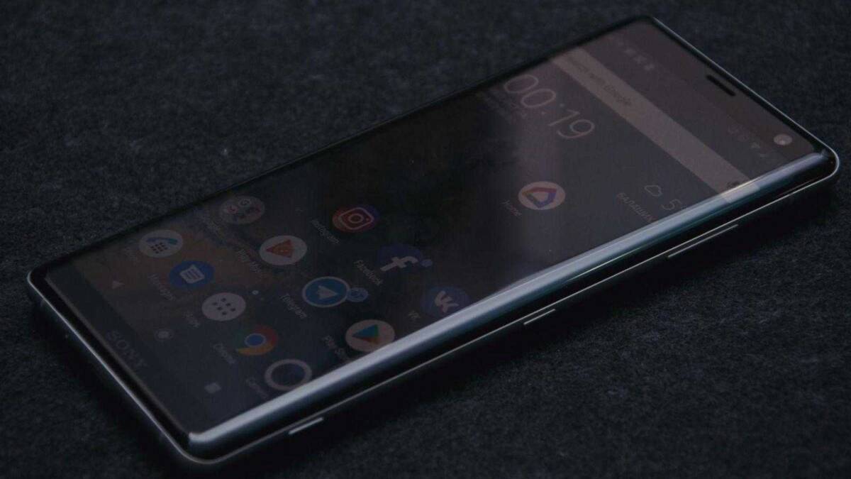 Sony Xperia XZ3 в руке лежит хорошо, и смотрится стильно. Смартфон Sony на черном фоне отображает интерфейс