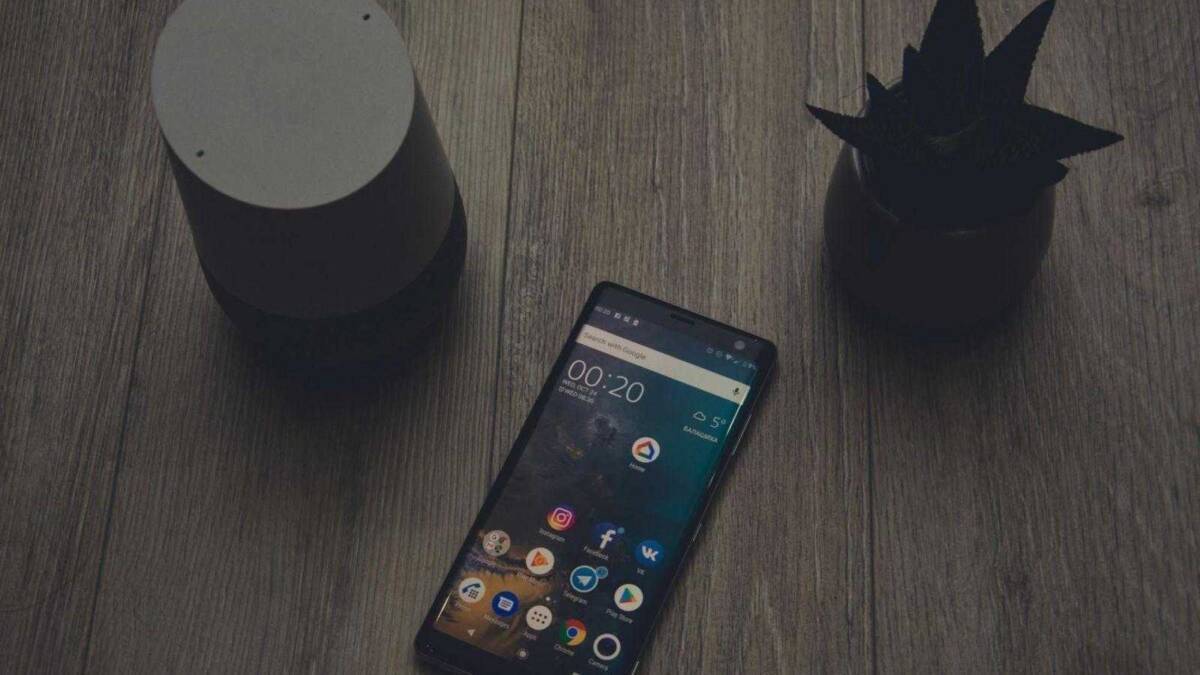 Обзор смартфона Sony Xperia XZ3. Идеальный флагман 21 Смартфон в центре окружен двумя декоративными горшками на деревянном столе