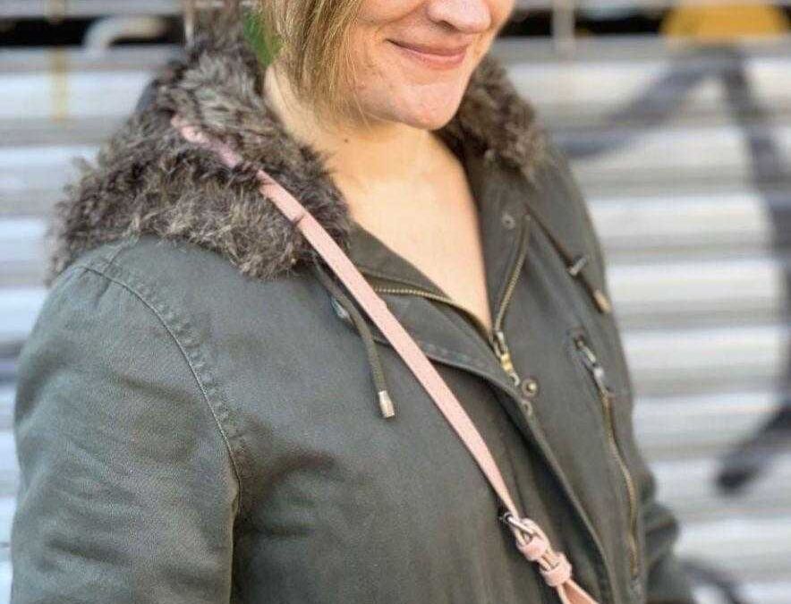 Женщина в парке с короткой стрижкой и курткой iPhone