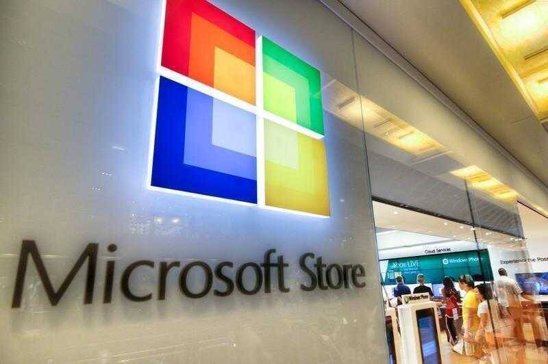 Витрина магазина Microsoft Store с логотипом и покупателями