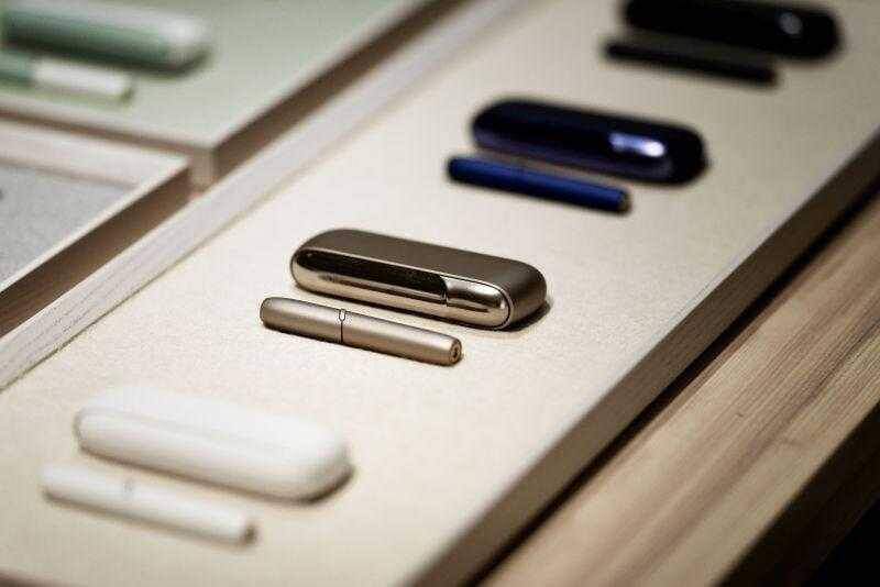 Различные устройства IQOS 3 и IQOS Multi на деревянной поверхности