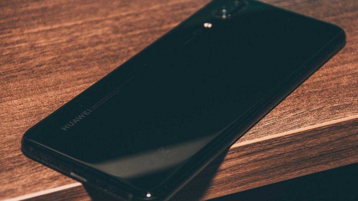 Обзор Huawei P20. Круче только Mate 19 Задняя панель Huawei с камерой и логотипом на деревянной поверхности