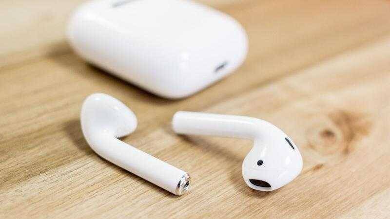 Беспроводные наушники AirPods с биометрическими датчиками на деревянной поверхности