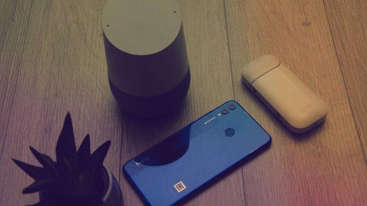 Смартфон Honor 8X на деревянной поверхности со спутником и подсвечником