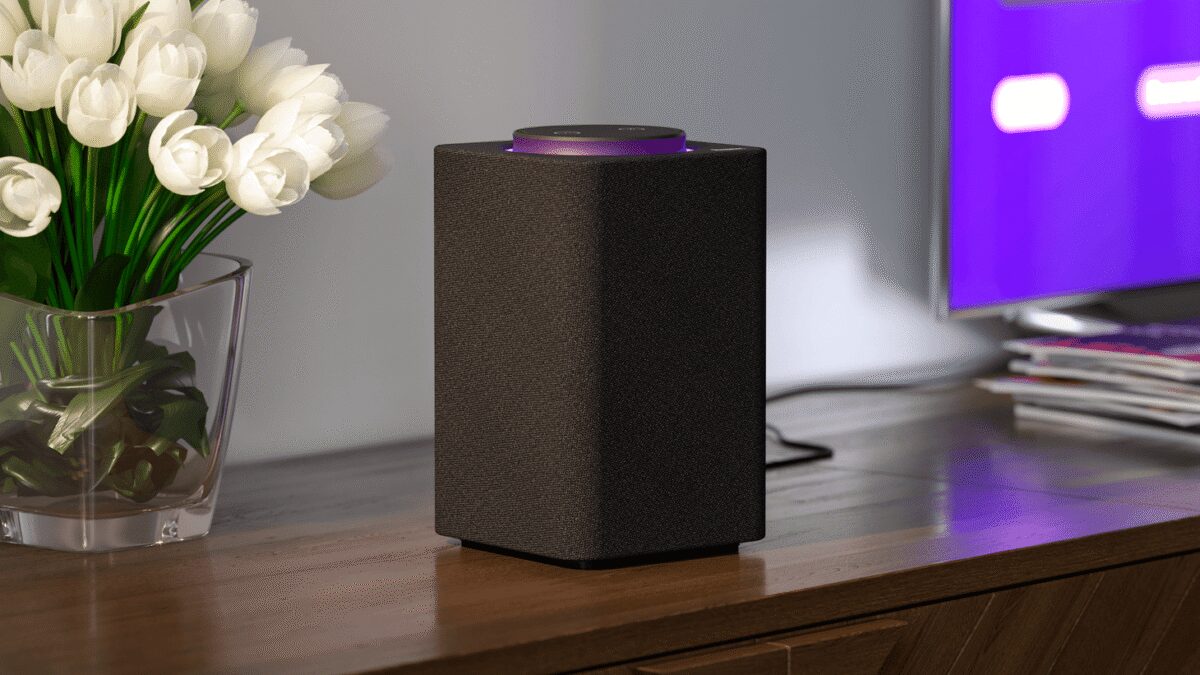 Акустическая система на деревянной поверхности рядом с цветком