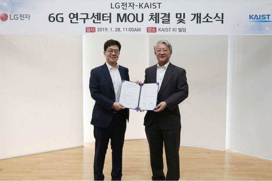 5G еще не работает, но LG уже готов к разработке 6G 3 Два мужчины держат открытую документацию на фоне баннера о 6G