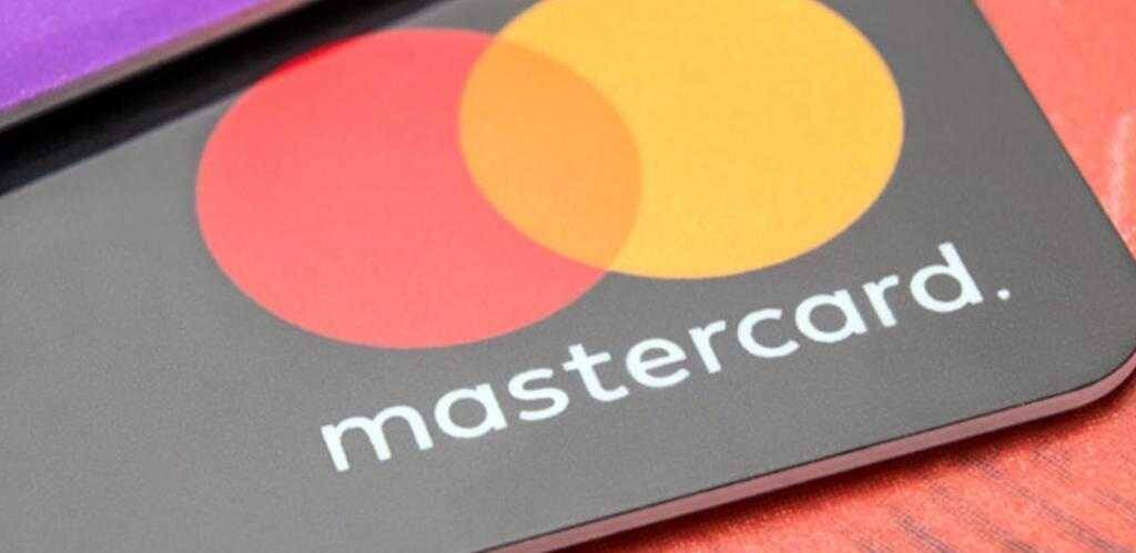Смартфон с логотипом Mastercard на экране и тёмный фон