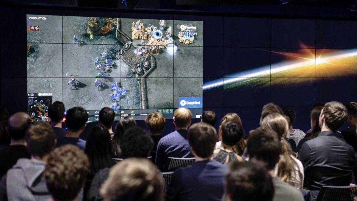 Люди смотрят на большой экран с игрой Starcraft II