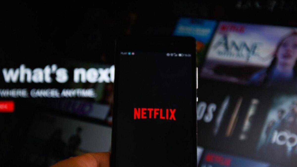 Мобильный телефон с логотипом Netflix на экране в руке