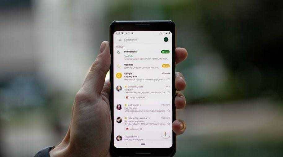 Рука держит смартфон с приложением Gmail на экране