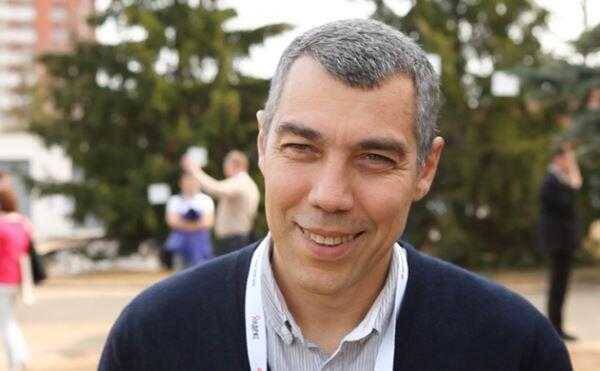 Мужчина улыбается на улице на фоне деревьев