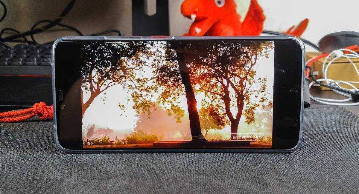 Мнение о Huawei Mate 20 Pro 19 Смартфон отображает сцену закатного неба с деревьями на экране