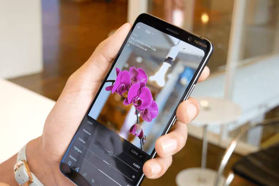 Рука держит Nokia 9 PureView с фотографией орхидеи