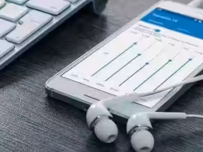 Смартфон с графиками данных и наушники на рабочем столе