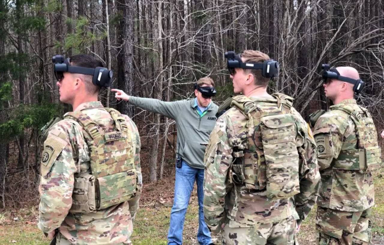 Группа военнослужащих в камуфляжной форме с VR-гарниторами на фоне деревьев
