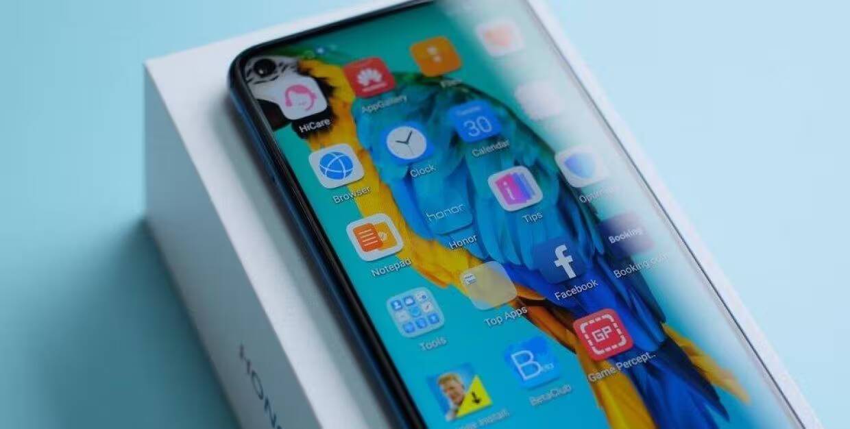 Смартфон Honor на белой коробке с ярким экраном