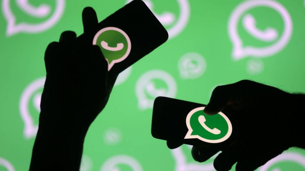 WhatsApp планирует увеличить лимит групповых видеозвонков 5 Темные силуэты держат смартфоны с логотипом WhatsApp