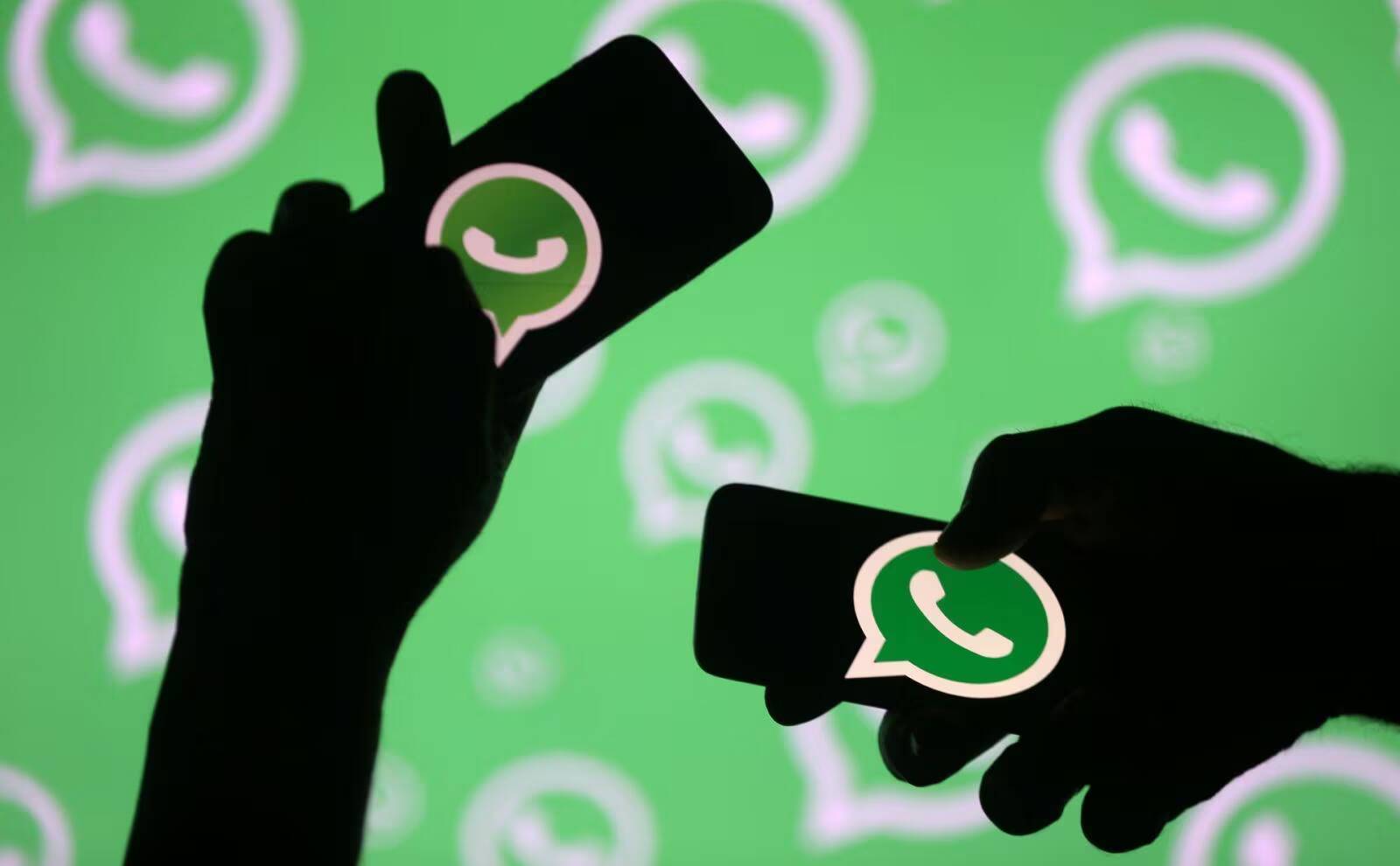 WhatsApp планирует увеличить лимит групповых видеозвонков 2 Темные силуэты держат смартфоны с логотипом WhatsApp