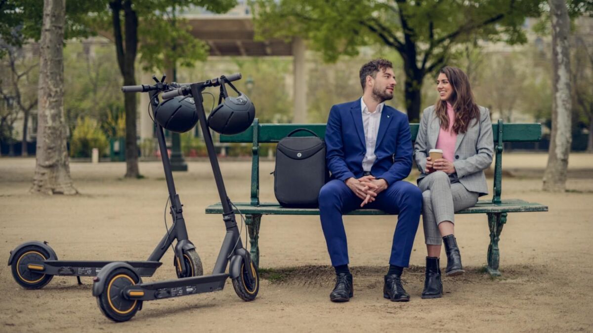 Двое человек на скамейке с электросамокатом Segway-Ninebot в парке