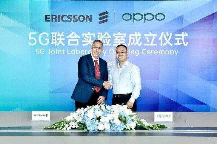 OPPO, Ericsson и MediaTek представили VoNR – технологию голосовых и видеозвонков в 5G-сетях 5 двое мужчин за столом в деловой одежде пожимают руки на фоне с логотипами Ericsson и Oppo