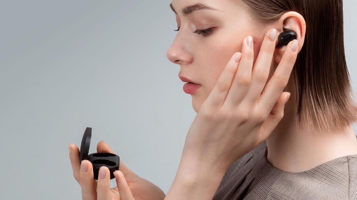 Молодая женщина с черными беспроводными наушниками Redmi AirDots S