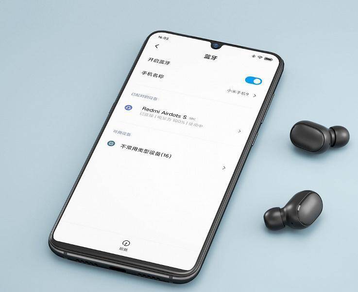 Смартфон Xiaomi с открытым настройками Bluetooth и наушники рядом