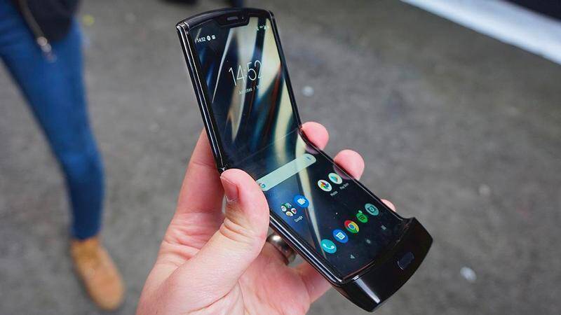 Раскладной телефон Motorola Razr в руке с включенным дисплеем