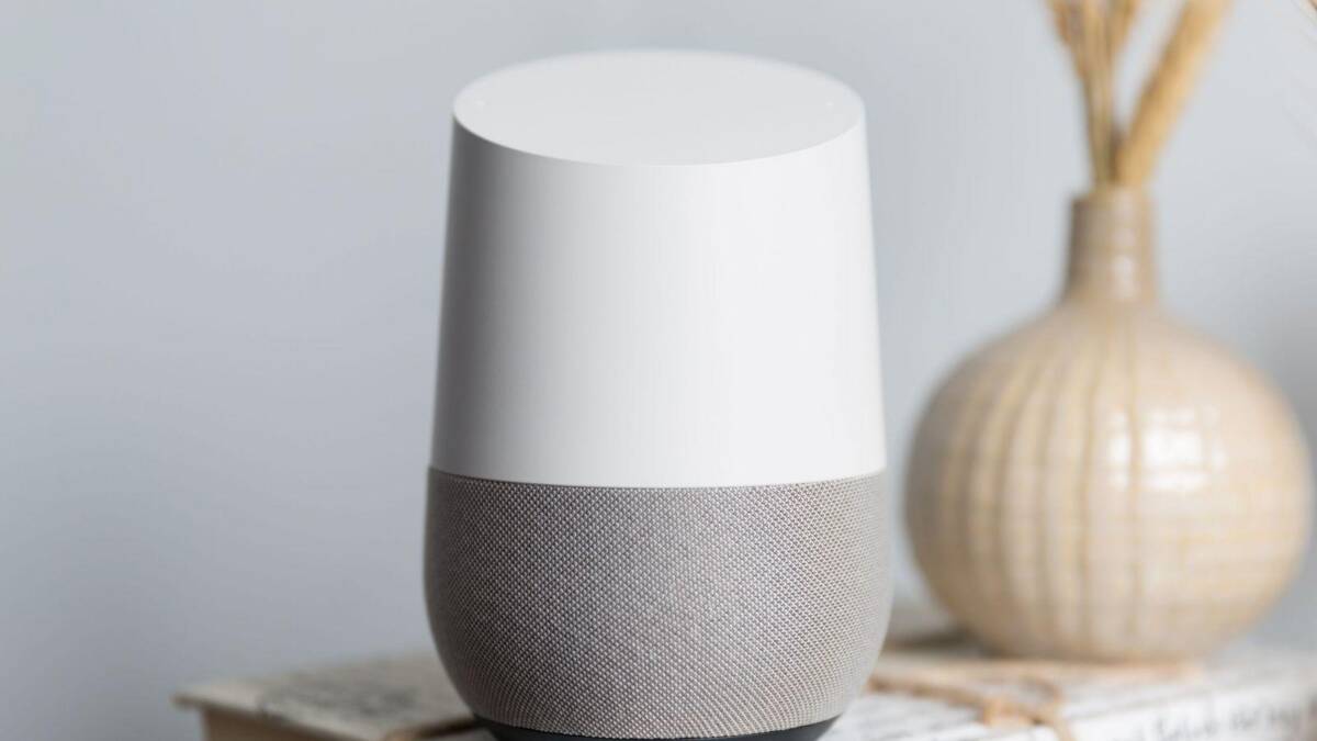 умный динамик Google Home на книжной полке в интерьере
