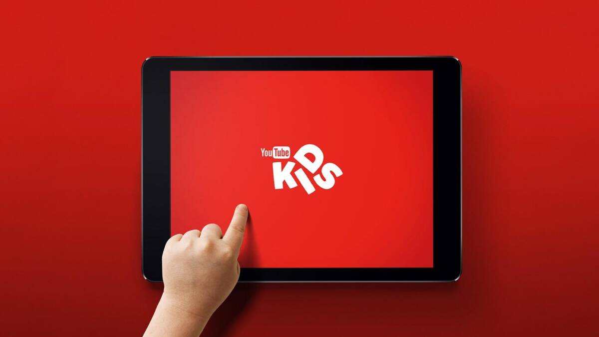 Планшет с запущенным приложением YouTube Kids на красном фоне