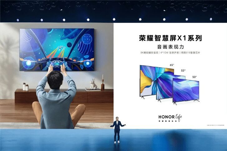 Человек смотрит телевизор Honor X1 на стене