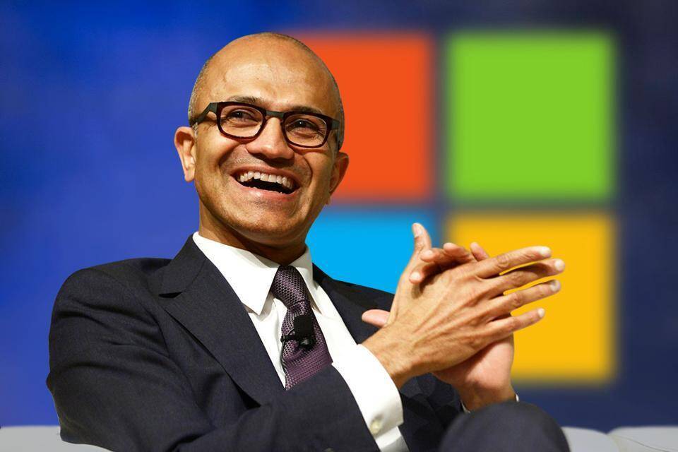 Генеральный директор Microsoft Сатья Наделла: постоянная работа на дому может нанести вред психическому здоровью 3 Человек в деловом костюме с микрофоном перед логотипом Windows