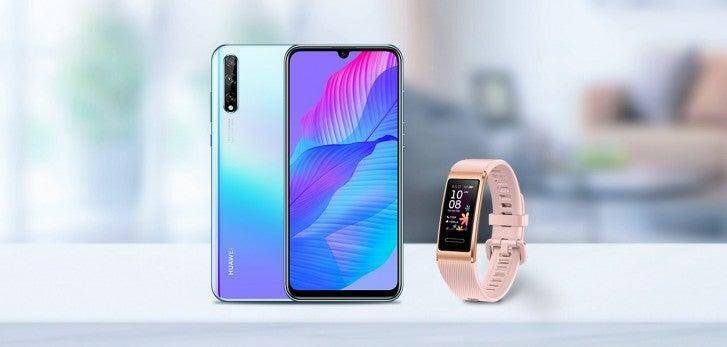 Смартфон Huawei и фитнес-браслет на светлом фоне