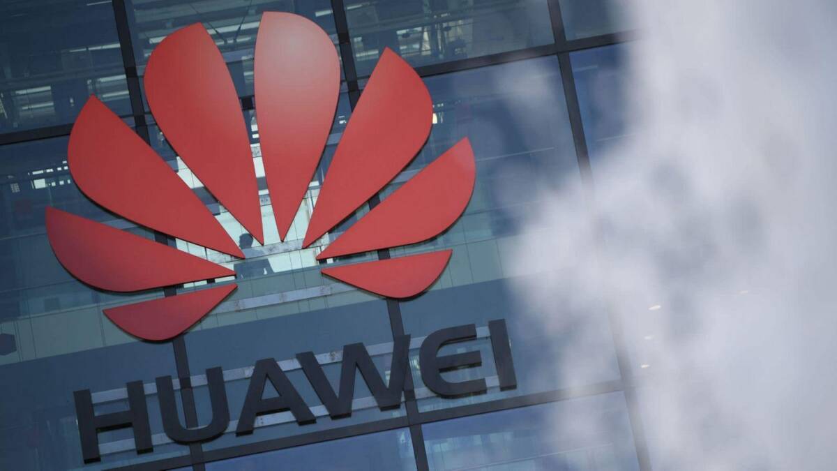 Логотип Huawei на стеклянной фасаде здания офисов