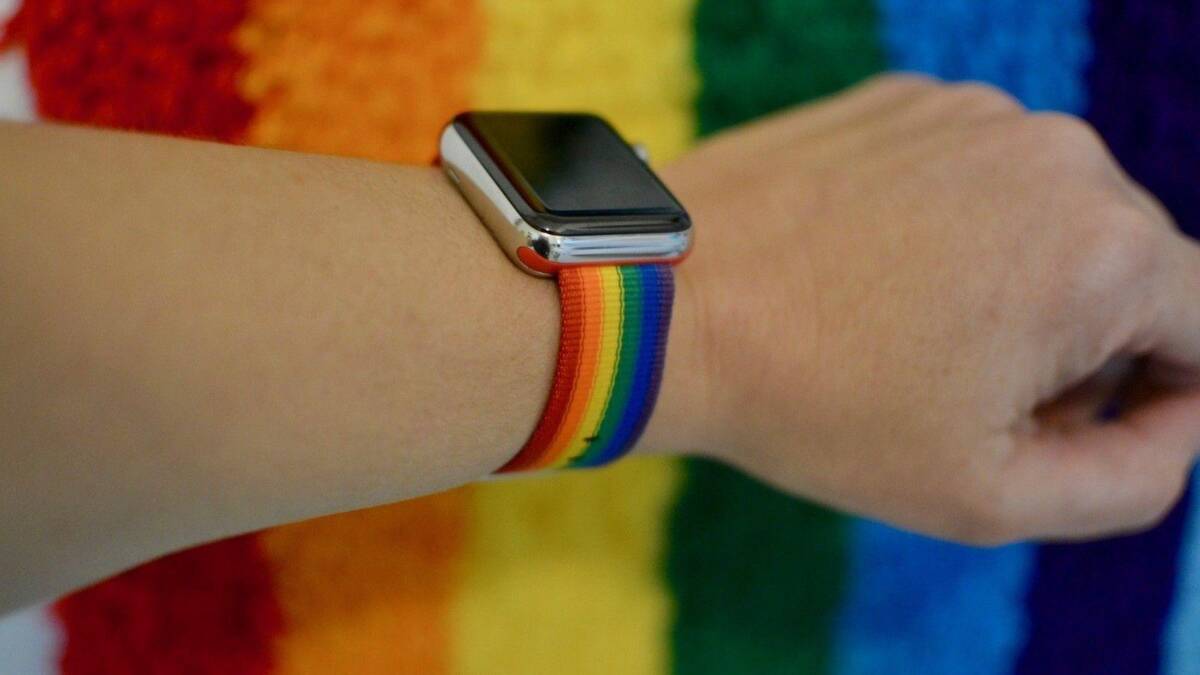 Рука с розоватым ремешком для Apple Watch Pride