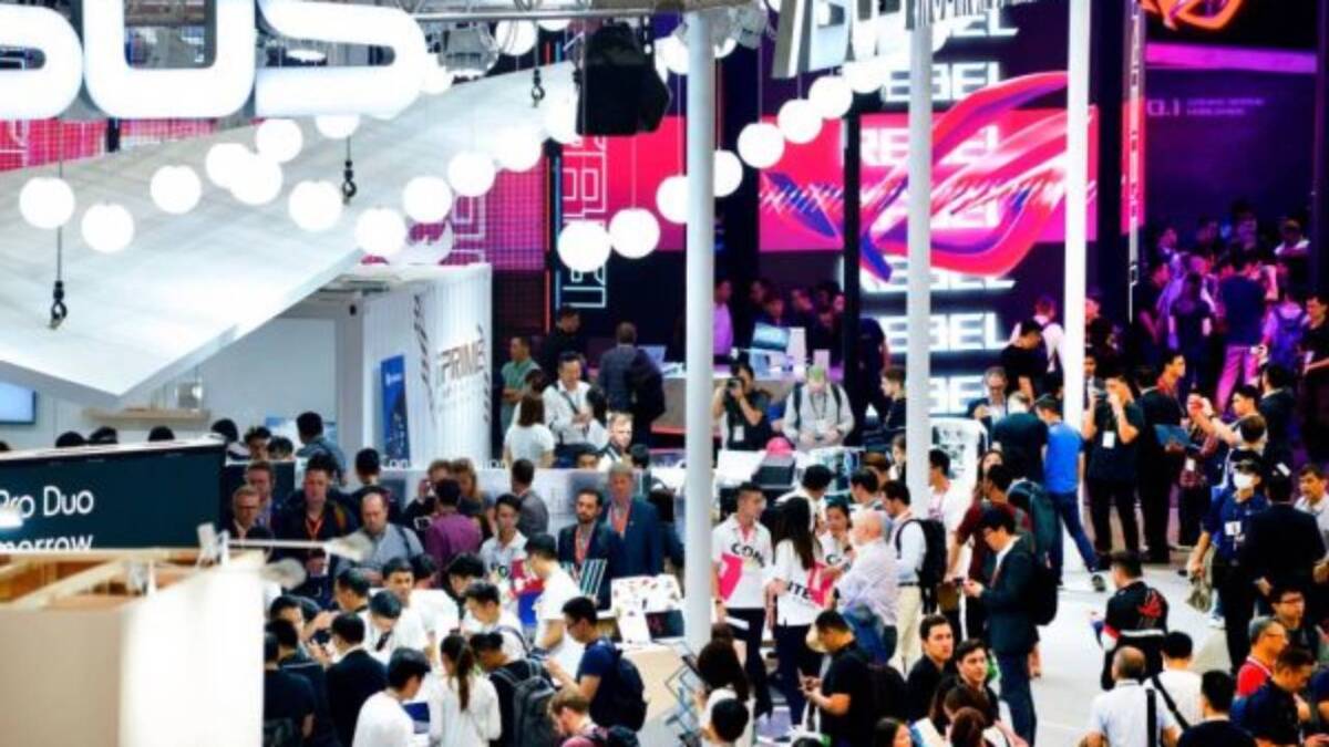 Толпа посетителей на выставке Computex 2020 с яркими рекламными экранами и стендами оборудования