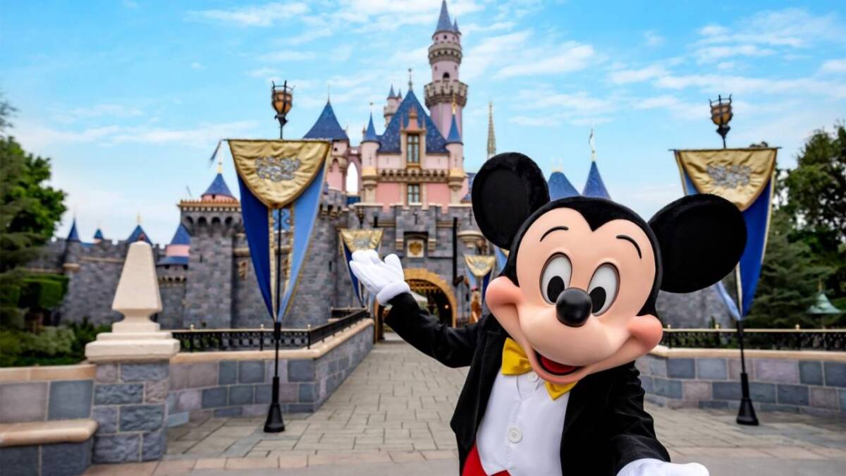 Disney поэтапно открывает свои парки в июле 3 Микки Маус в костюме на фоне замка Диснея