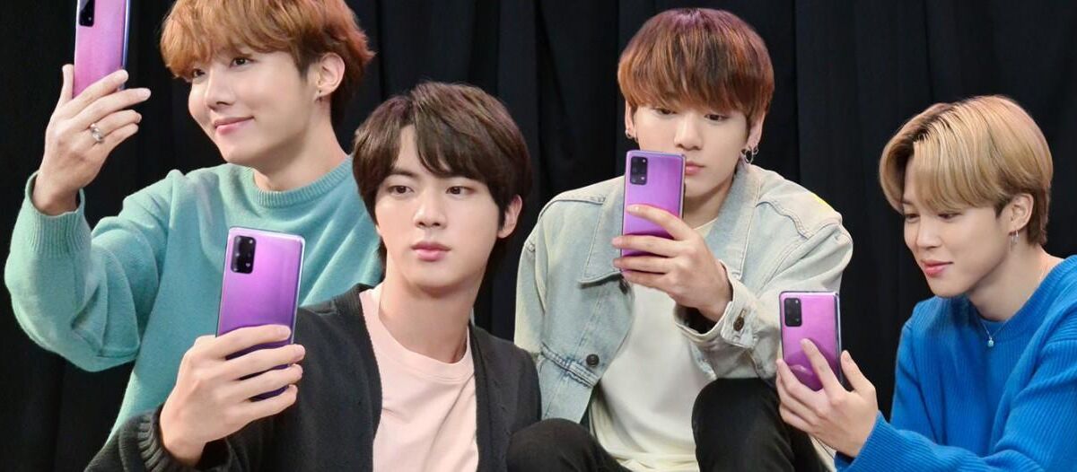 Группа из пяти молодых людей с телефонами Galaxy S20+ BTS Edition