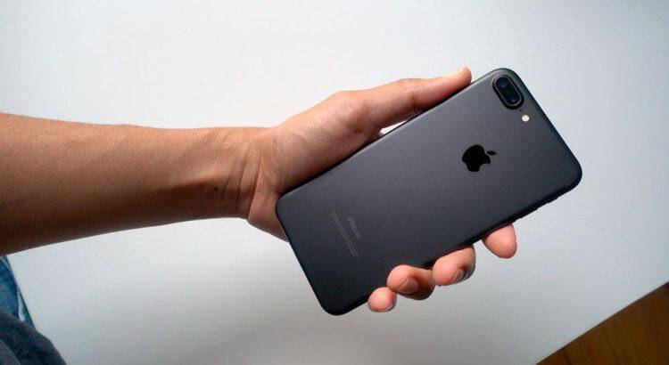 iPhone 7 признан самым популярным смартфонов у россиян 4 Человек держит черный iPhone 7 с двойной камерой