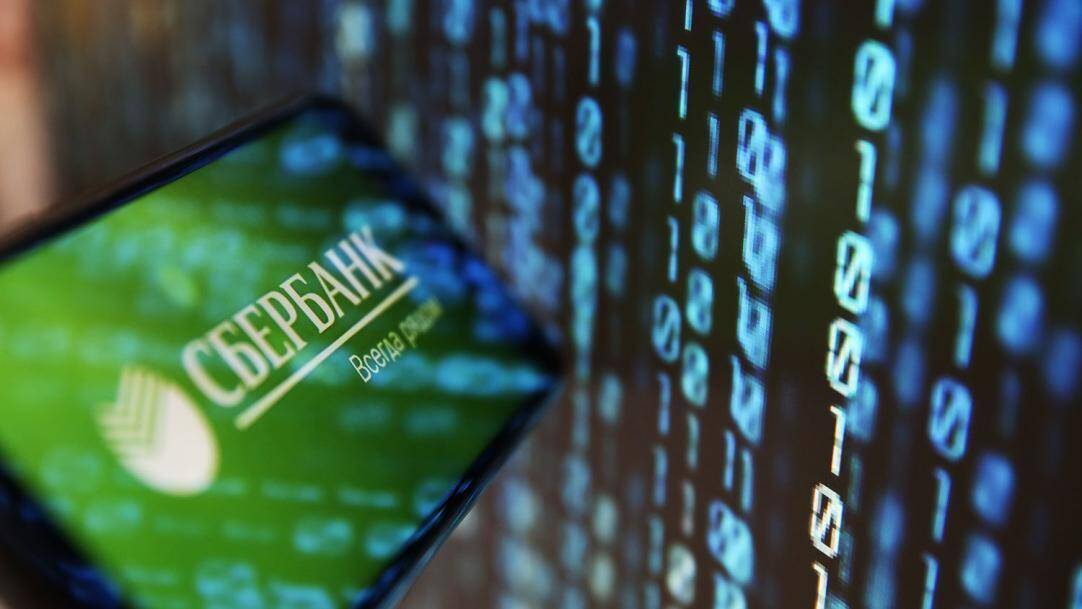 Смартфон с логотипом Сбербанка и экраном в руке