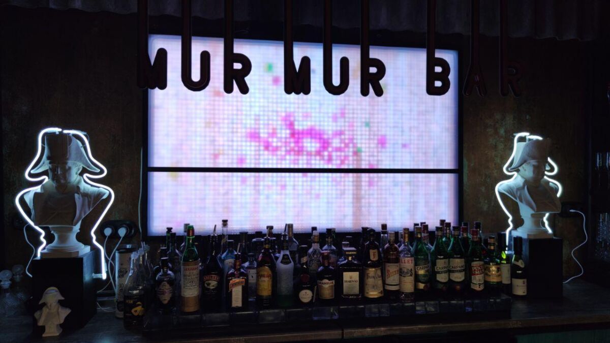 Бар с напитками у светящейся скульптуры бюста Мур Мур Барт в баре Мур Мур Бар
