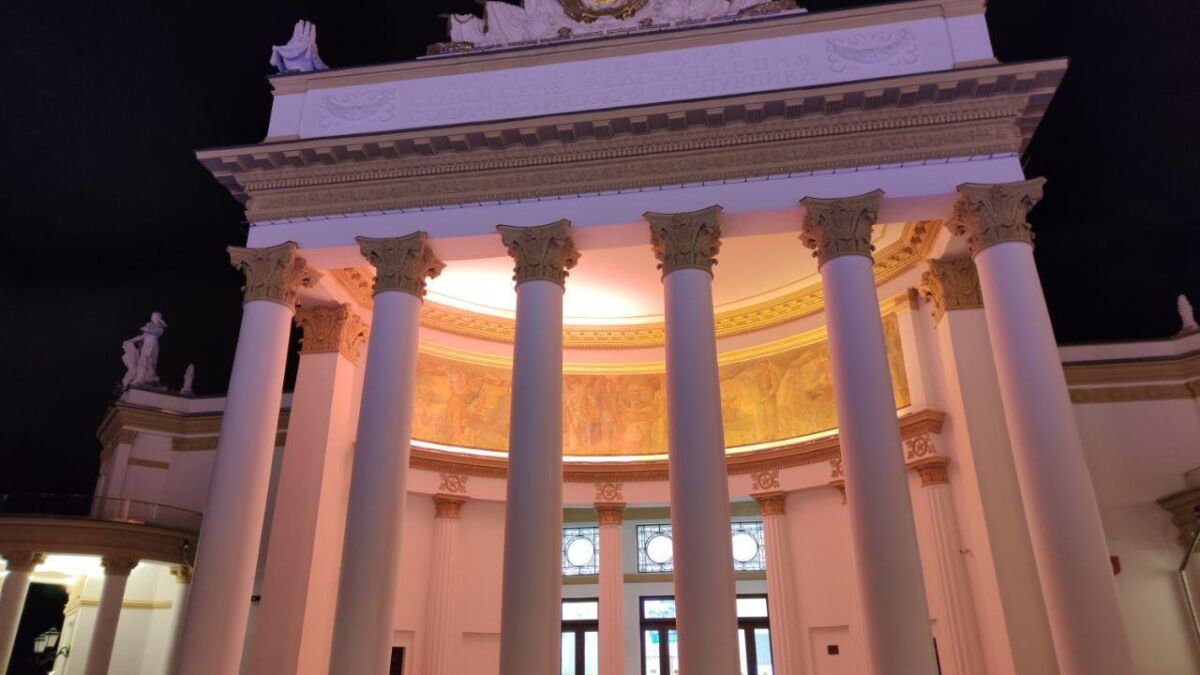 Здание с классическими колоннами и статуями ночью