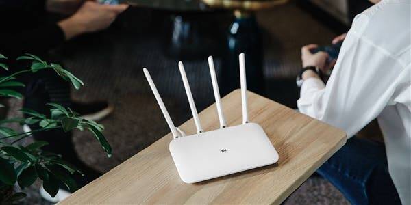 В продажу поступил Xiaomi Router 4 Pro за 28 долларов 5 Белый Wi-Fi маршрутизатор с четырьмя антеннами на деревянной поверхности