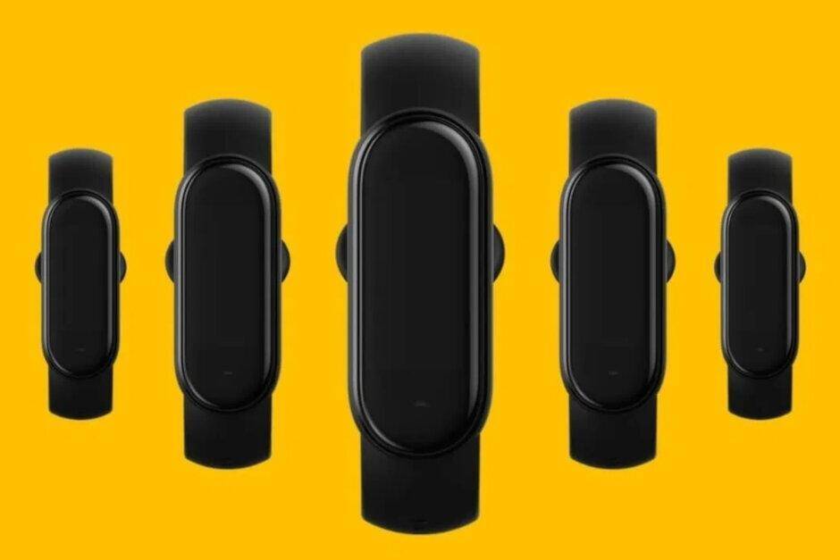 Четыре умных браслета Xiaomi Mi Band 5 разные размеры черные на желтом фоне