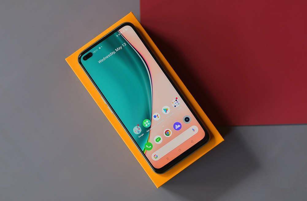 Смартфон Realme на оранцевой коробке со дисплеем