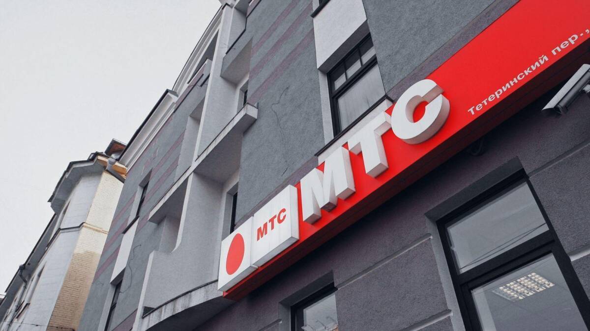 Вывеска МТС на сером здании со окнами